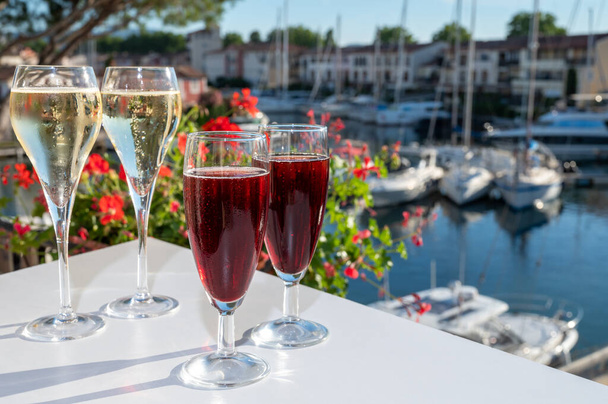 Fiesta de verano con cóctel real kir, degustación de vino espumoso de champán francés brut y creme cassis fría en copas en el puerto deportivo de Port Grimaud cerca de Saint-Tropez, vacaciones en la Riviera francesa, Francia - Foto, imagen