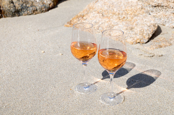 Nyaralás Provence-ban, két pohár hideg rózsa bor a homokos tengerparton Saint-Tropez közelében napsütésben, Var megye, Franciaország - Fotó, kép