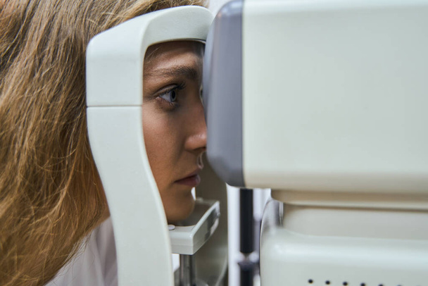 Beautiful young woman having eye examining in clinic - Photo, Image