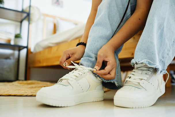Chica poniendo en zapatillas de cerca - Foto, imagen