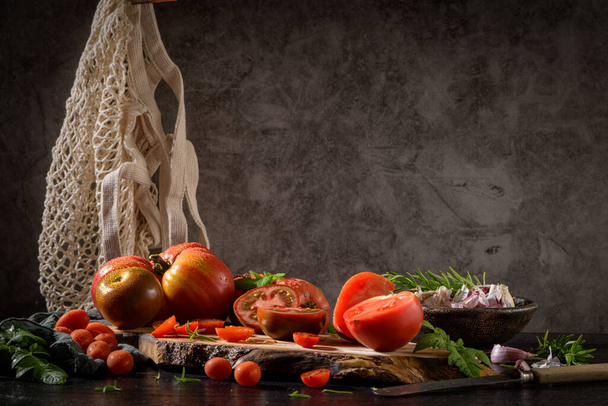 Large variety of tomatoes on rustic kitchen counter. Preparation of tomato sauce. - Foto, immagini