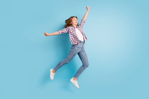 Full size photo of young happy cheerful smiling excited girl jumping look copyspace isolated on blue color background - Valokuva, kuva