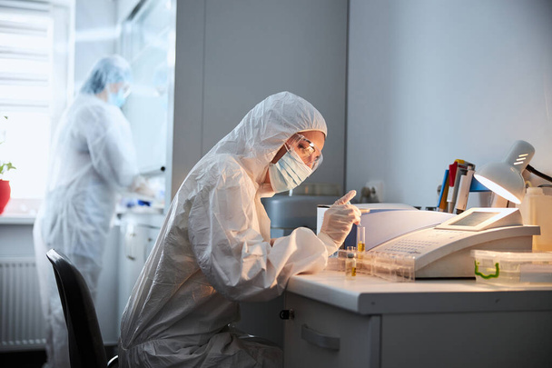 Два вирусолога проводят химические испытания в исследовательской лаборатории - Фото, изображение