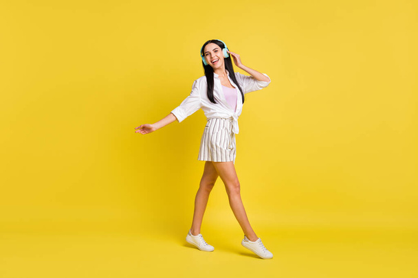Full size photo of young happy cheerful smiling positive girl dancing listen music isolated on yellow color background - Фото, зображення