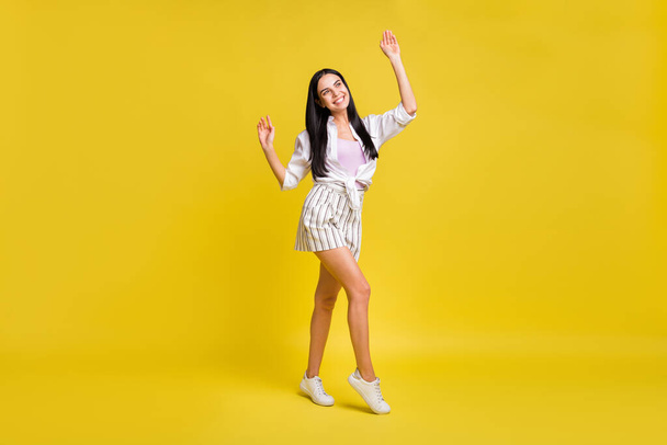Full size photo of young excited smiling positive dreamy girl look copyspace dancing isolated on yellow color background - Фото, изображение