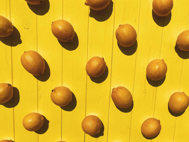 Fresh lemons on wooden background, top view. Ripe fruit. - Photo, image