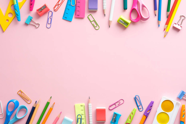 Back to school concept. Frame of school supplies on pink background. Flat lay, top view, overhead - 写真・画像