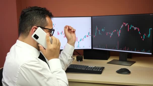 Акціонерний брокер робить телефонний дзвінок про біржові діаграми
 - Кадри, відео