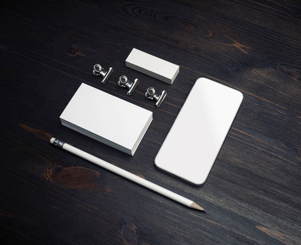 木製テーブルの上のスマートフォン、空白の名刺、鉛筆、消しゴムの写真背景. - 写真・画像