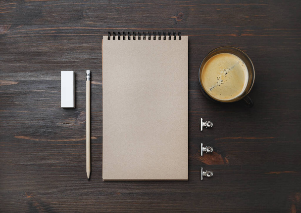 Coffee cup and blank stationery: kraft notebook, pencil and eraser on wood table background. Flat lay. - Photo, Image