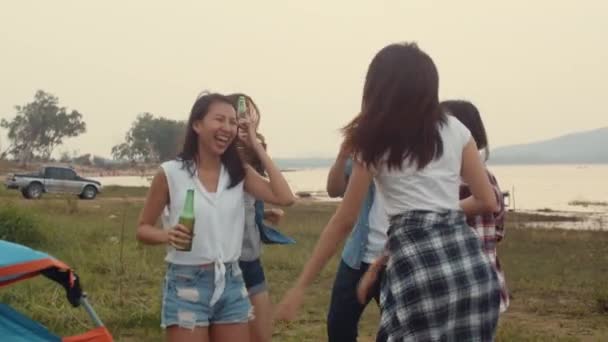 Groupe de l'Asie meilleurs amis adolescents dansant et buvant ont plaisir à saluer toast de bière bouteille profiter de la fête avec des moments heureux ensemble dans le camping. Sur le fond belle nature, montagnes et lac. - Séquence, vidéo