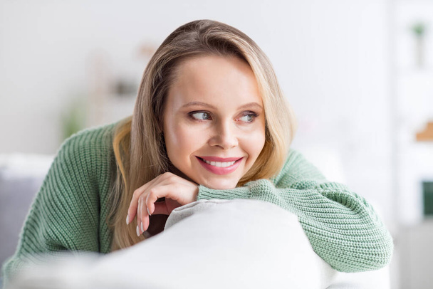 Portrait of attractive calm peaceful dreamy cheerful wavy-haired girl sitting on comfy divan dreaming at home light white flat room indoors - Zdjęcie, obraz