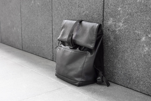 Black backpack near grey wall - Foto, imagen