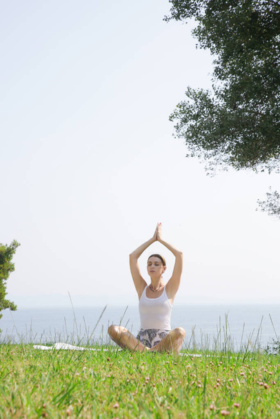 Jeune femme pratiquant le yoga en plein air, concept de bien-être et de soins personnels - Photo, image