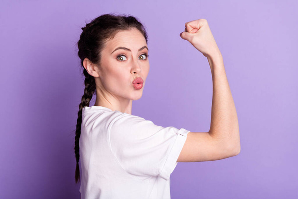 Profile side photo of funky happy young woman send air kiss show biceps win isolated on purple color background - Photo, Image