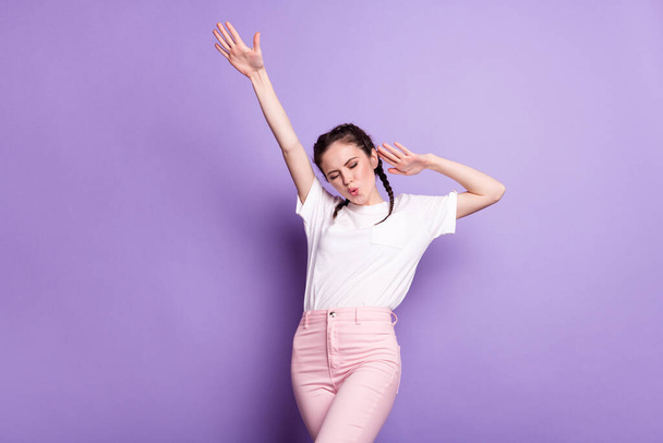Photo of happy nice dreamy young woman enjoy dance raise hands good mood isolated on purple color background - Photo, image
