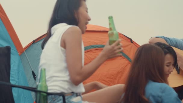 Grupa Azji najlepsi przyjaciele nastolatki pić piwo chill dance cieszyć się muzyką gitarową z szczęśliwych chwil razem obok namiotów w obozie parku narodowego. Na tle piękna przyroda, góry i jezioro. - Materiał filmowy, wideo