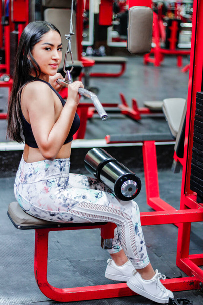 Mujer joven entrenando en un gimnasio - Photo, image
