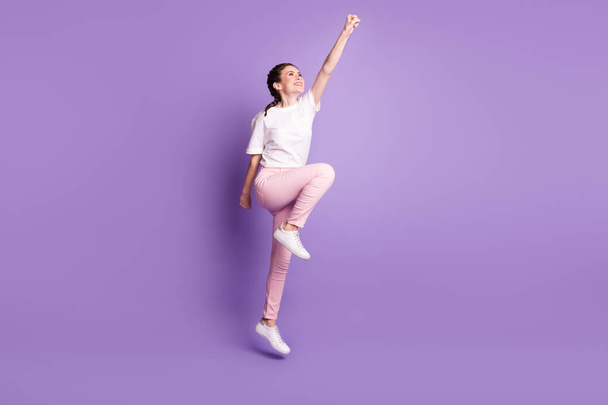 Full size profile side photo of young attractive girl happy positive smile jump superhero isolated over violet color background - 写真・画像