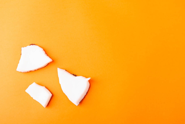 Happy coconuts day concept, fresh coconut group pieces slices, studio shot isolated on orange background - Photo, image
