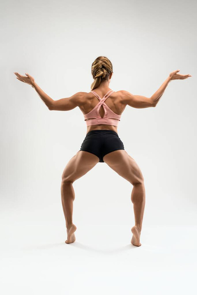 Muscular woman in sports underwear standing in Goddess pose - Photo, image