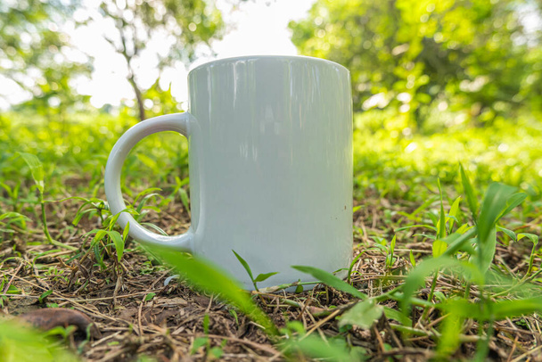 mug mockup with green grass in the garden in summe - Photo, Image