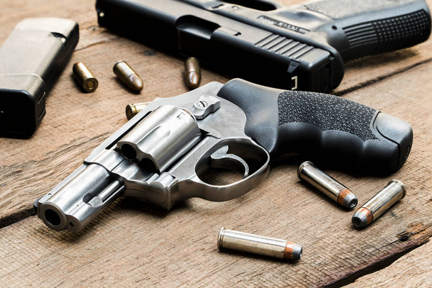 .Rewolwer 357 magnum, pistolet 9mm, naboje i magazynki na drewnianym stole - Zdjęcie, obraz