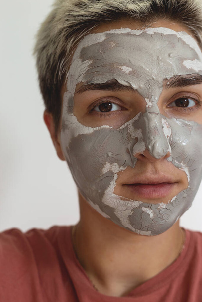 Cropped shot of woman apply grey green skincare clay mask on face. Daily beauty skin care routine. Close up view.  - Foto, Imagen