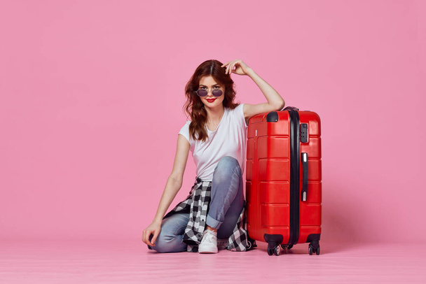 Kırmızı valizli bir kadın tatil hayatı sürüyor. - Fotoğraf, Görsel