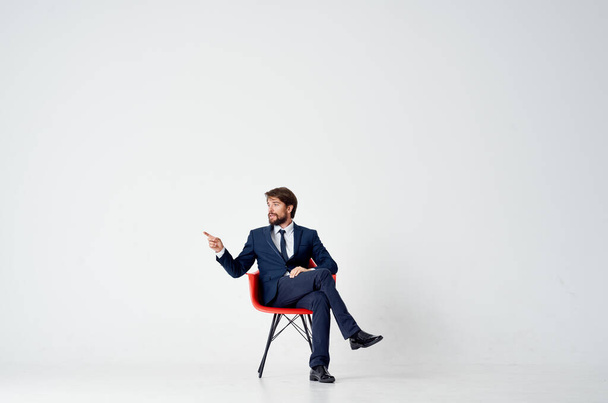 business man in suit sitting on red chair emotions office - Photo, Image