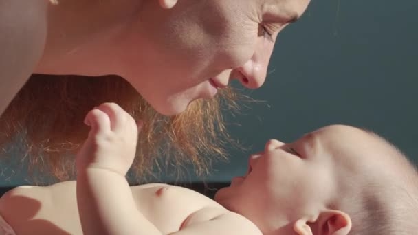 Close-up shot van jonge moeder speelt met haar pasgeboren baby in een kinderkamer in een ochtend. Concept van kinderen, baby, ouderschap, kindertijd, leven, moederschap, moederschap. - Video