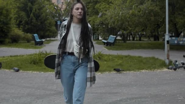 Girl skateboarder walking outdoors - Footage, Video