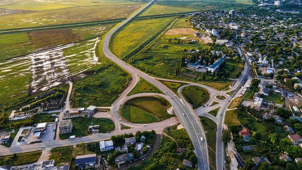 Drohnenaufnahme eines Dorfes und einer Straße in seiner Nähe, grüne Felder, Moldawien - Foto, Bild