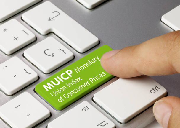 MUICP Monetary Union Index of Consumer Prices Written on Green Key of Metallic Keyboard. Naciśnięcie klawisza palca. - Zdjęcie, obraz
