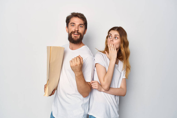 молода пара в білих футболках паперовий мішок покупки
 - Фото, зображення