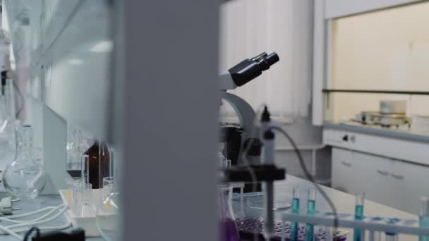化学実験室内のスローモーショントラッキング顕微鏡、ラック、ビーカー、フラスコの試験管がテーブルにあります。 - 映像、動画