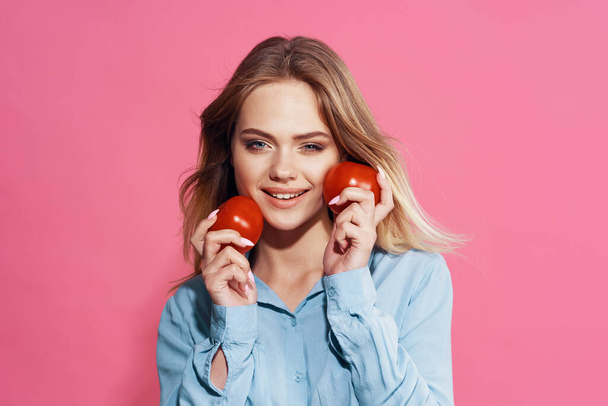 pretty woman in blue shirt with tomatoes in her hands food - Foto, afbeelding