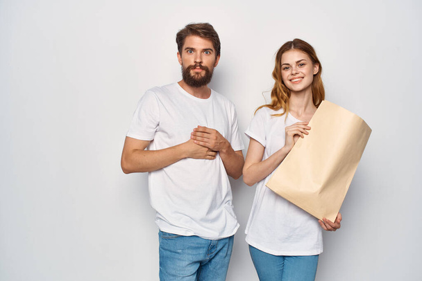 чоловік і жінка в білих футболках паперовий мішок покупки
 - Фото, зображення