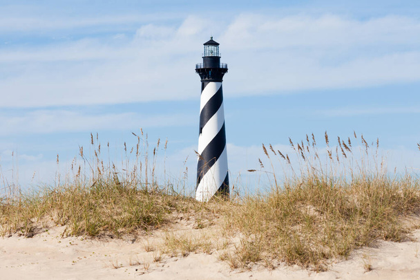 Cape Hatteras Lighthouse towers over beach dunes of Outer Banks island near Buxton, North Carolina, US - Photo, Image