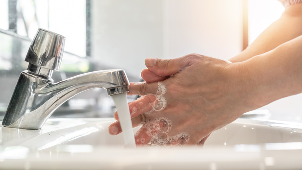 Se laver les mains en frottant avec du savon liquide antibactérien pour la désinfection, la protection contre le covide-19, la prévention du virus de la couronne et l'hygiène pour arrêter la propagation du coronavirus en utilisant de l'eau du robinet et un désinfectant à l'évier - Photo, image