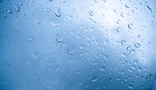Krople deszczu na oknie. Niebieski sygnał - Zdjęcie, obraz