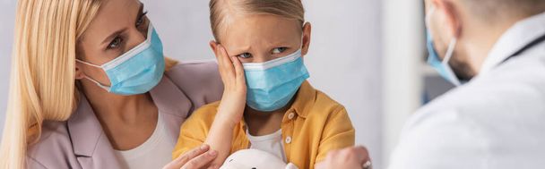 Sick kid in medical mask looking at doctor near mother, banner  - Photo, Image