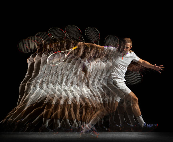 Young man, professional tennis player in motion and action isolated on dark background. Stroboscope effect. - Foto, afbeelding