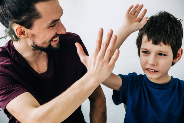 Professional psychologist tutor man cheerfully plays with an autism child during therapy. Autism, asperger child lifestyle concept - Photo, Image
