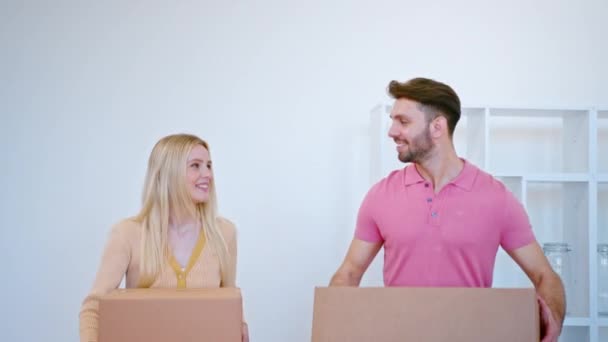 pareja romántica lleva cajas caminando a lo largo de nuevo apartamento - Metraje, vídeo