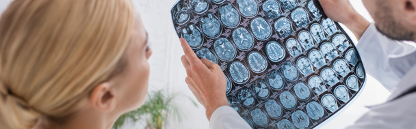 doctor sosteniendo cerebro mri scan cerca de mujer en hospital, bandera - Foto, Imagen