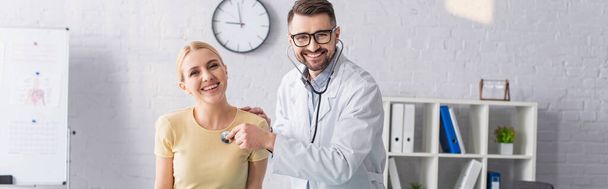 happy doctor and patient looking at camera during diagnostics in clinic, banner - Photo, Image