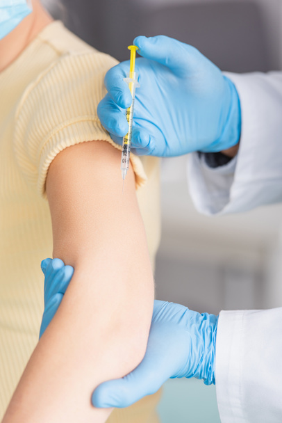καλλιεργημένη άποψη του γιατρού σε γάντια λατέξ εμβολιάζοντας γυναίκα - Φωτογραφία, εικόνα