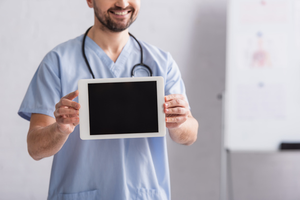 partial view of smiling doctor showing digital tablet with blank screen - Photo, Image