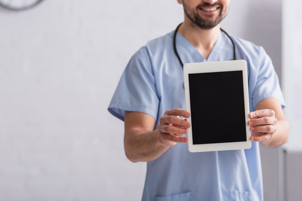 cropped view of smiling doctor in blue uniform holding digital tablet with blank screen - Fotoğraf, Görsel